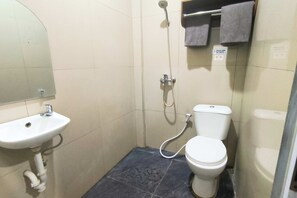 Ein kleines Badezimmer mit Waschbecken, Toilette und Dusche.