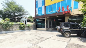 A building with a sign for 'J&L INN' and a black SUV parked in front. - J&L Inn Semarang (Semarang)
