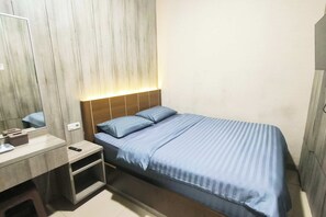 Ein Schlafzimmer mit Bett, Nachttisch und Spiegel.