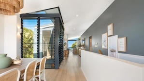 Un interior moderno con comedor, cocina y vistas al exterior.