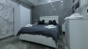 Ein modernes Schlafzimmer mit einem Bett, einem Kleiderschrank, einem Schminktisch und einer Wand mit Bildern.