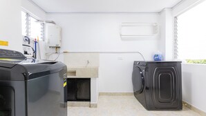 A laundry area with a washing machine, dryer, and a water heater. - Large Hidden Gem in Poblado with A/C and gym. Steps from Provenza / Lleras. (Medellín)