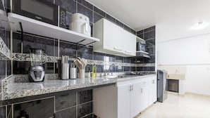 A modern kitchen with a built-in microwave, a blender, and a coffee maker on the countertop. - Large Hidden Gem in Poblado with A/C and gym. Steps from Provenza / Lleras. (Medellín)