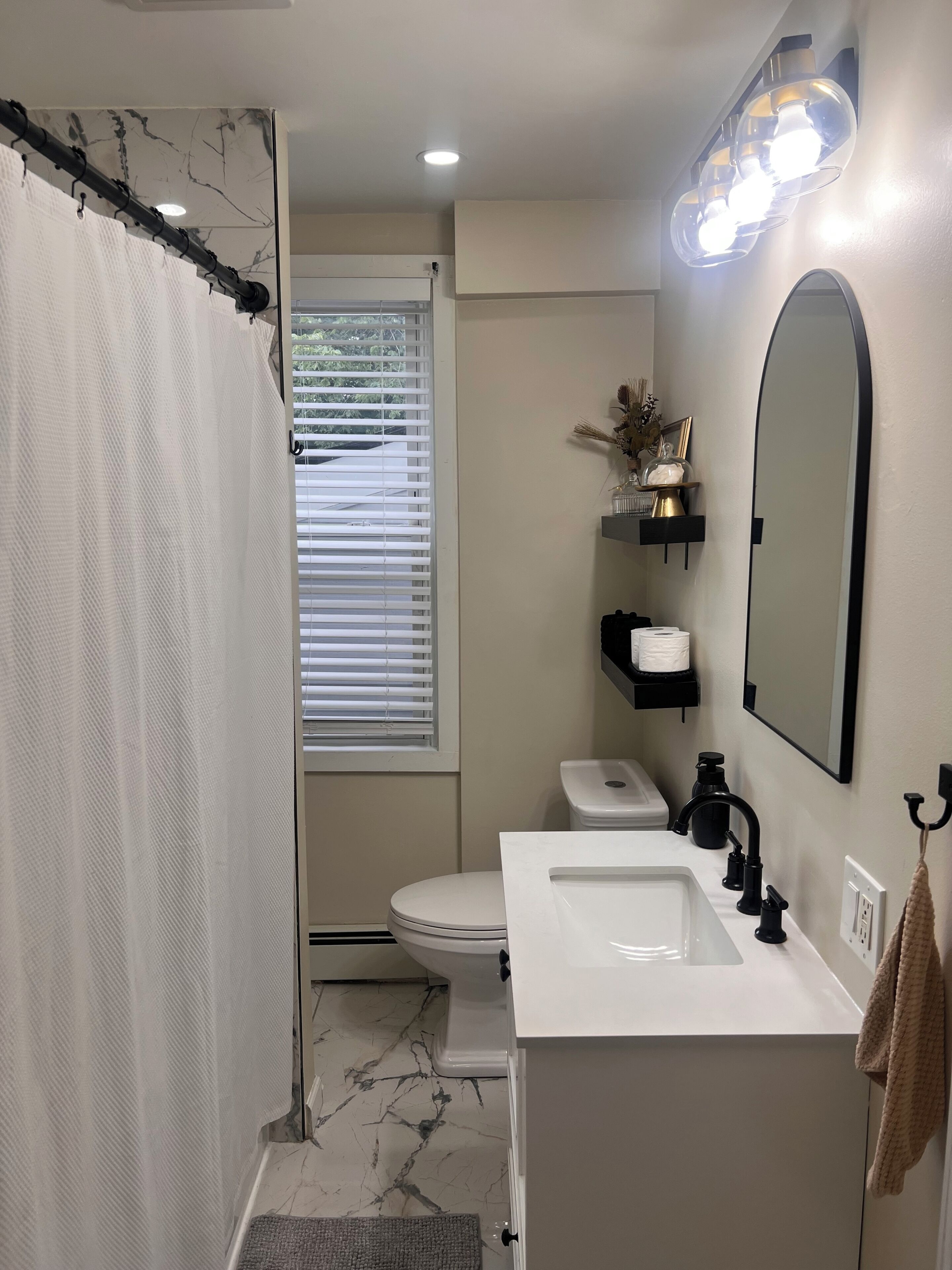 A bathroom with a toilet, sink, and shower curtain.