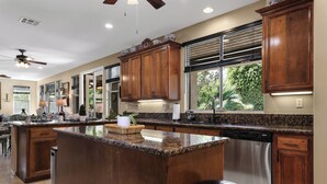 Una cocina amplia con una isla grande, armarios de madera y un lavavajillas de acero inoxidable.
