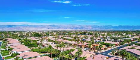 Zona residencial con casas, palmeras y montañas al fondo.