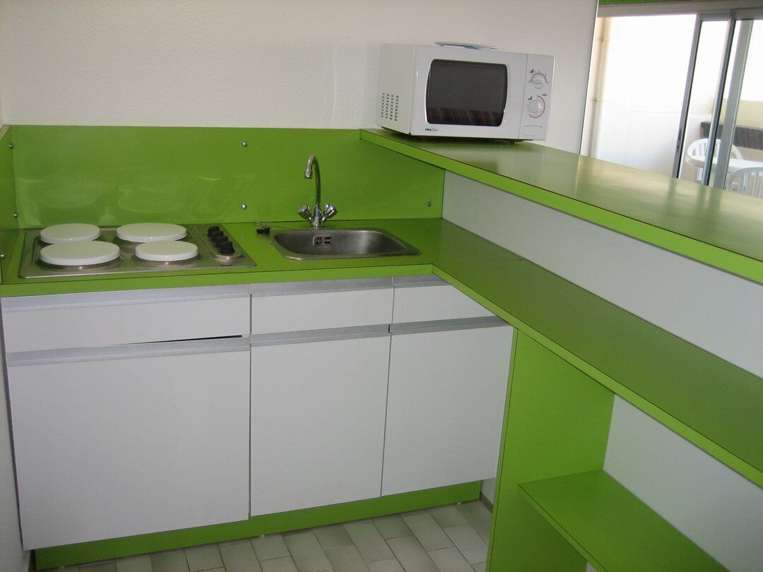 A kitchen with a microwave, sink, and four burners.
