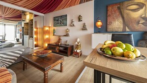 Ein Zimmer mit Esstisch, Obstschale und Buddha-Statue.