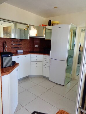 A compact kitchen with white cabinets, a granite countertop, and a white refrigerator. - NAUTIC - Port Nature Apartment PN583 - Luxury - 2 people (AGDE)