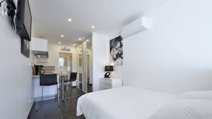 A hotel room with a bed, a desk, a chair, and a painting on the wall. - POPPY - Port Nature Studio 461 - Luxury - 2 people (AGDE)