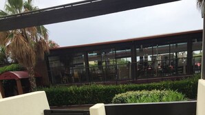 An outdoor patio with a table and chairs, a water feature, and a view of a building with large windows. - POPPY - Port Nature Studio 461 - Luxury - 2 people (AGDE)