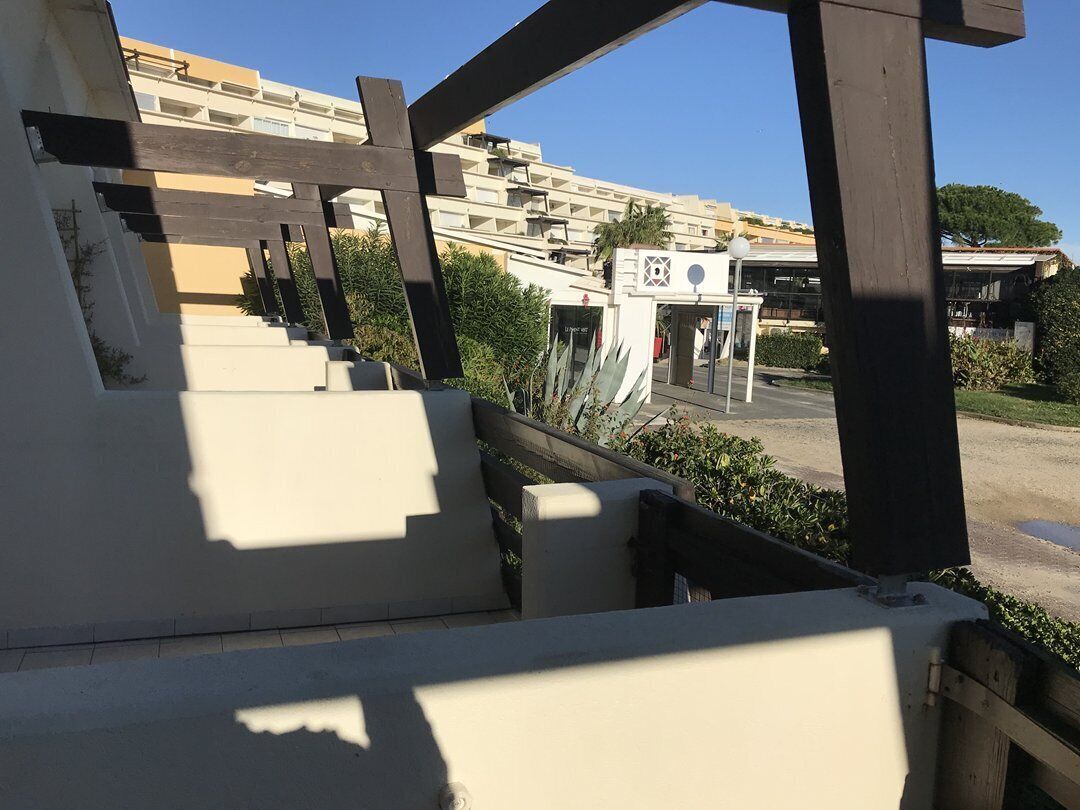 Una escala condueix a un edifici de façana blanca, amb un cel blau de fons.