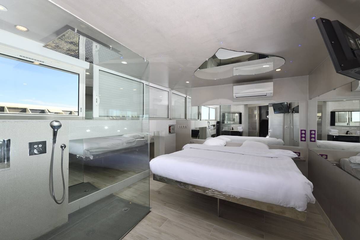 Une chambre d’hôtel moderne dotée d’un grand lit, d’une douche et d’un téléviseur.
