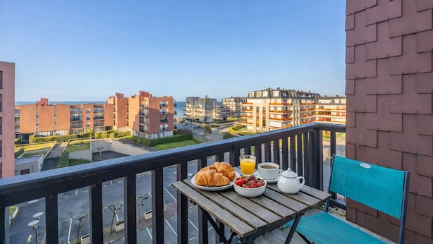A balcony with breakfast items, a view of residential buildings, and a clear sky. - Le Nid de Cabourg - Welkeys (Cabourg)