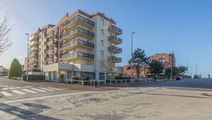 A multi-story residential building with balconies, a crosswalk, and a clear sky. - Le Nid de Cabourg - Welkeys (Cabourg)