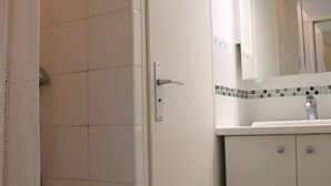 Un bagno con doccia, lavabo e specchio.