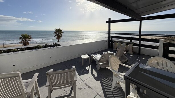 A covered outdoor seating area with a view of the beach and ocean. - LA BELLE VUE - Studio Port Nature Studio 115s with garage - Luxe - Seafront - 2 people (AGDE)