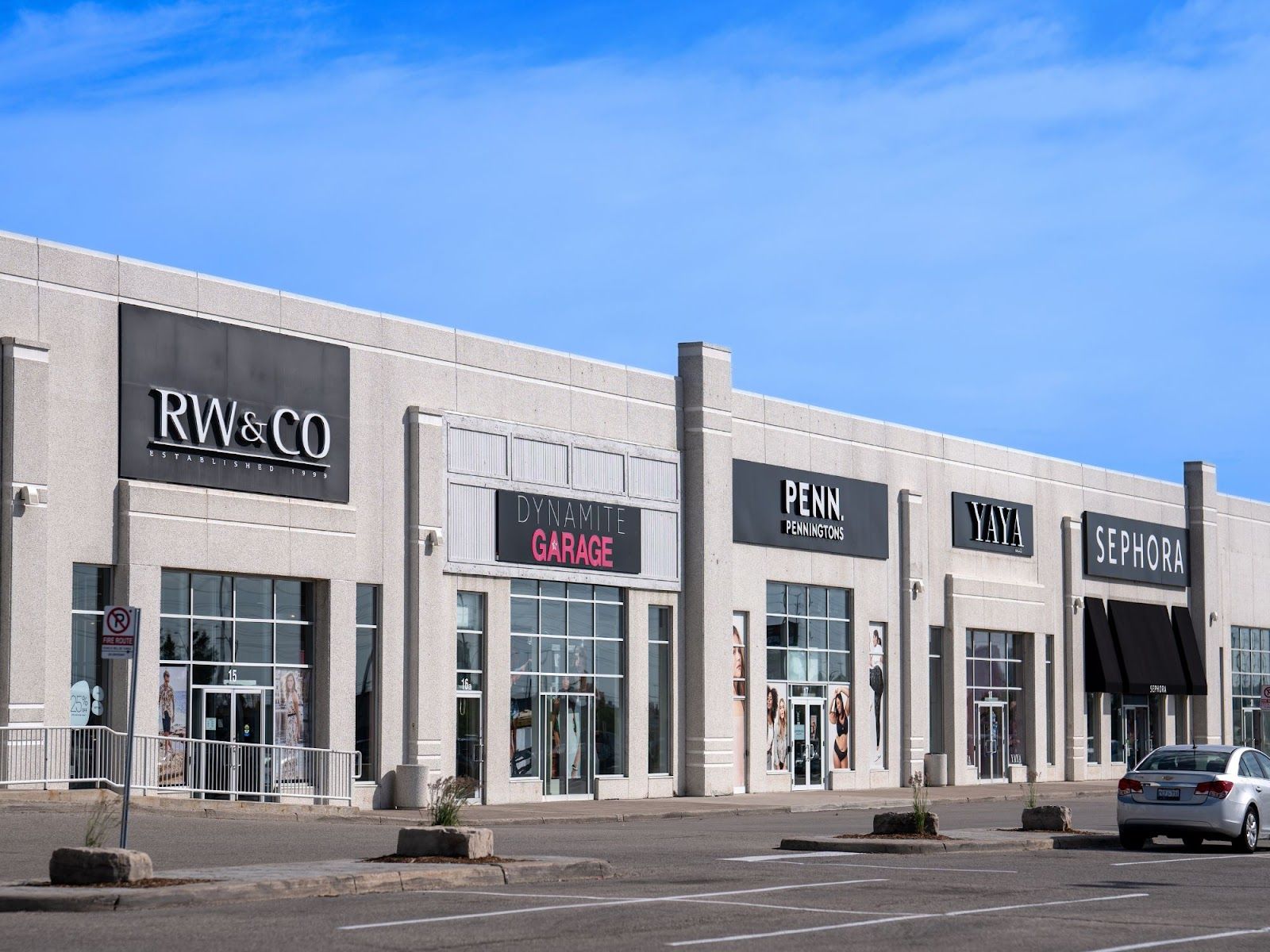Un immeuble commercial abritant plusieurs boutiques, notamment RW&CO, Dynamite Garage, Penningtons, Yaya et Sephora.