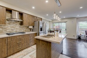 A modern kitchen with wooden cabinets, a central island, stainless steel appliances, and pendant lighting. - Spacious Upscale 4BR Detached Retreat with Parking (Mississauga)