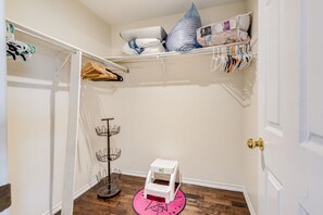Una habitación compacta con armario, un pequeño taburete y un zapatero.