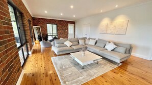 A modern living room with a sectional sofa, a coffee table, and a large window.