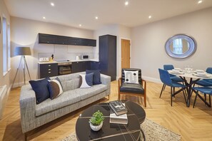 Una sala de estar moderna con sofá, mesa de centro y comedor.