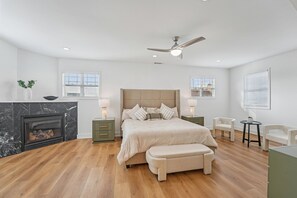 A bedroom with a bed, a ceiling fan, a fireplace, and two bedside tables. - New 8bd 7.5ba 6,600 sq ft Home in O4W Inman Park WALKABLE ATL Eastside Beltline (Atlanta)