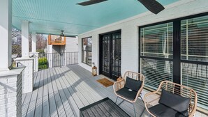 A covered outdoor area with a ceiling fan, wicker chairs, and large windows. - New 8bd 7.5ba 6,600 sq ft Home in O4W Inman Park WALKABLE ATL Eastside Beltline (Atlanta)