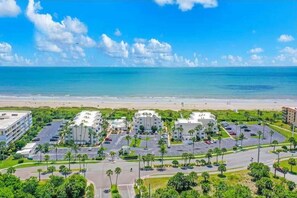 A coastal hotel area with multiple buildings, parking lots, and a beach in the background. - Direct Oceanfront Condo W/ Private Balcony, Heated Pool & Hot Tub! ☀️ (Cape Canaveral)