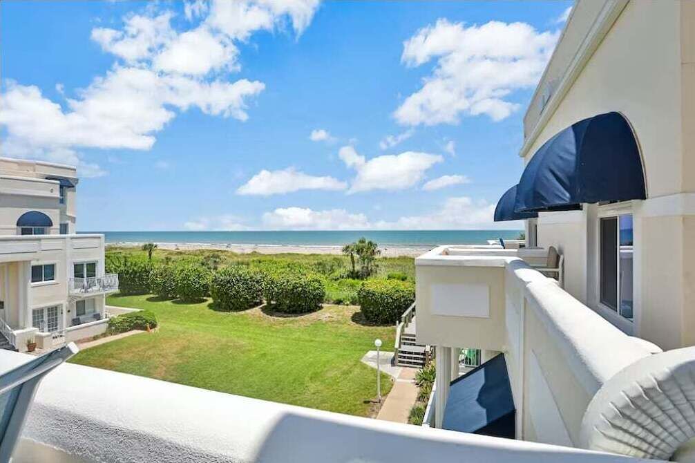 Uma varanda com vista para a praia e o oceano.