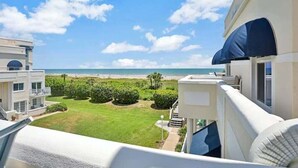 Ein Balkon mit Blick auf Strand und Meer.