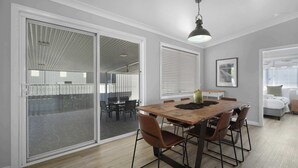 A dining area with a table, chairs, and a ceiling light.