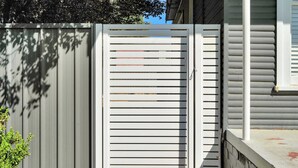 A gated area with a metal fence and a white gate.