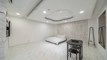 Un dormitorio con una cama, una mesita y una silla.