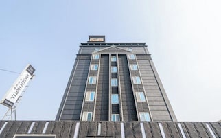 A tall building with a modern architectural design, featuring a series of windows and a central entrance.