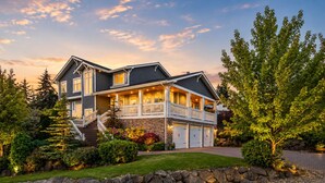 A two-story house with a front porch, stone retaining wall, and a driveway. - Beautiful Eastside 5 bedroom resort like home with Hot-tub and AC (Newcastle)