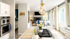A modern kitchen with a central island, stainless steel appliances, and pendant lighting. - Beautiful Eastside 5 bedroom resort like home with Hot-tub and AC (Newcastle)