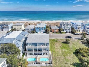A coastal residential area with houses, a road, and a beach. - Sun Sprinkles by Carolina Getaway - Ocean Views, Pool, Walk to Kure Beach (Kure Beach)