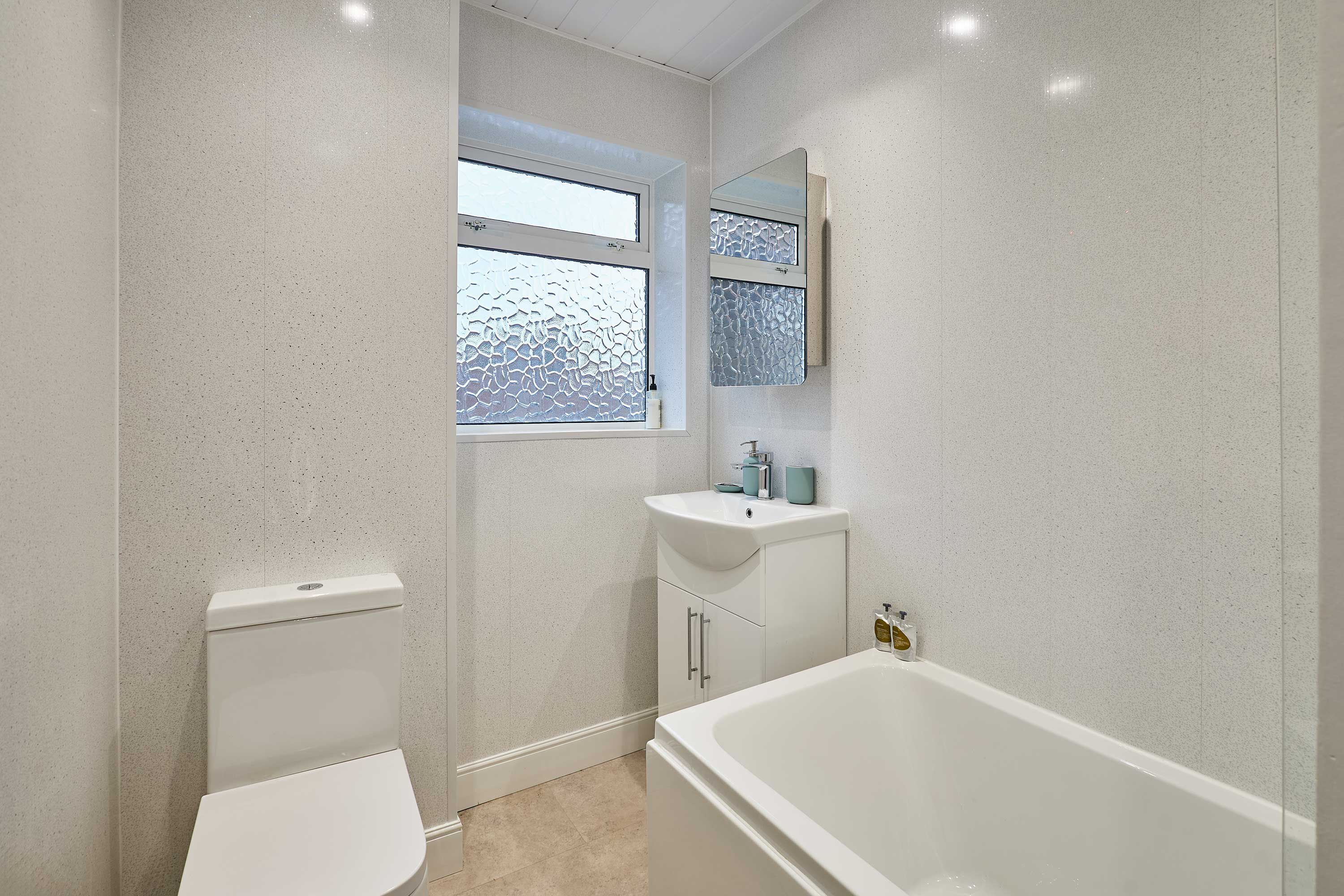 A bathroom with a toilet, sink, and bathtub.