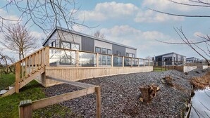 A modern house with a wooden deck and a glass conservatory. - Host Stay Kingfisher Lodge Amotherby (Malton)