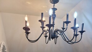 Uma escadaria com guarda-corpos de madeira e um candelabro com várias luzes.