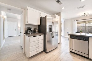 A modern kitchen with a refrigerator, coffee maker, and dishwasher. - Modern 3BR Home | Pets+7 Min to Airport+Parking (Las Vegas)