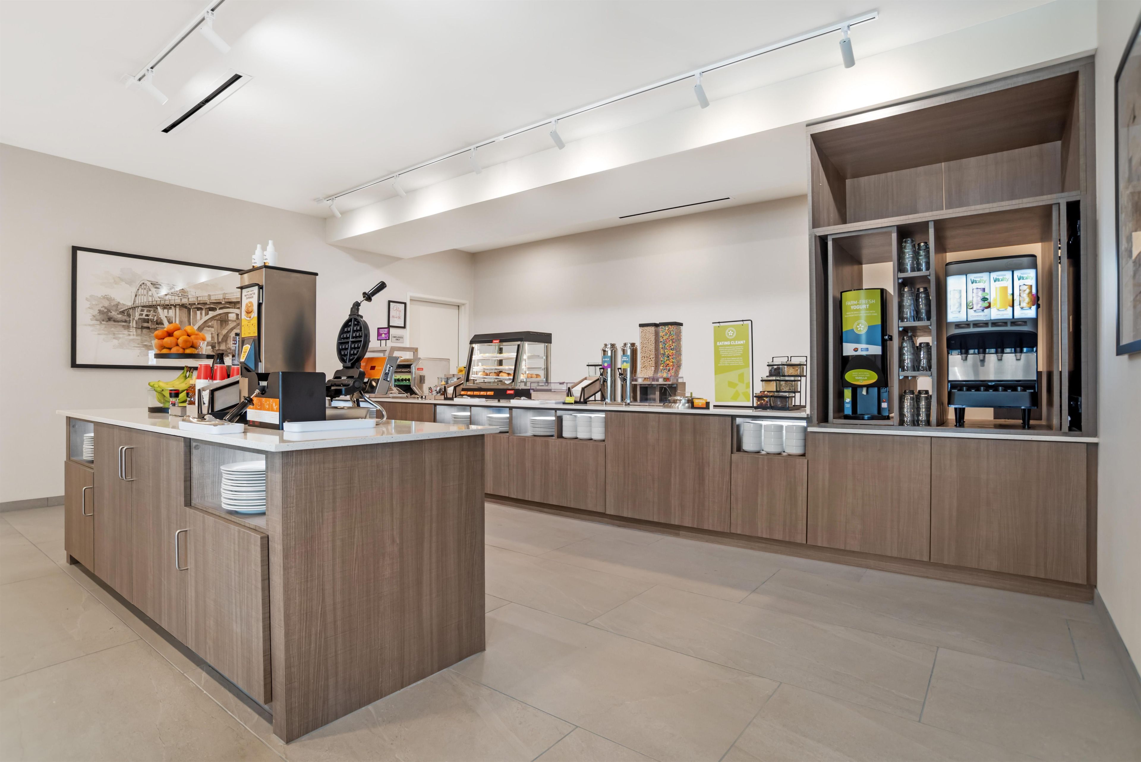 Una cocina moderna con una isla central, armarios integrados y una estación para café.