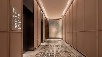 A hotel corridor with a floor plan sign indicating guest rooms, meeting rooms, and retail areas.