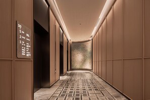 Un pasillo de hotel con un cartel de plano de planta que indica habitaciones de huéspedes, salas de reuniones y zonas comerciales.