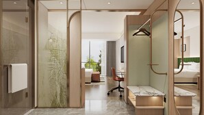 Een moderne hotelkamer met een inloopkast, een zithoek en uitzicht op het landschap.