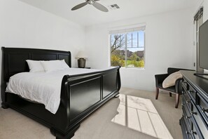 A bedroom with a bed, a nightstand, a lamp, a dresser, a chair, a window, and a ceiling fan. -  3-bedroom townhome on the ninth fairway fabulous Troon North Golf Course. (Scottsdale)
