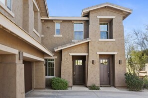 A two-story building with a flat roof, a front door, and a small porch area. -  3-bedroom townhome on the ninth fairway fabulous Troon North Golf Course. (Scottsdale)