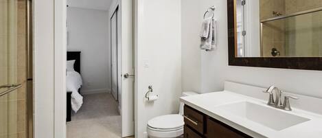 Un baño con lavamanos blanco, un espejo y un inodoro.