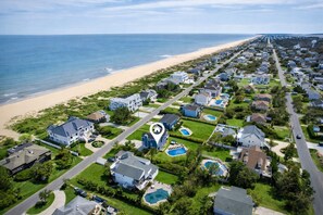 Une zone résidentielle côtière avec des maisons, une plage et une longue route.